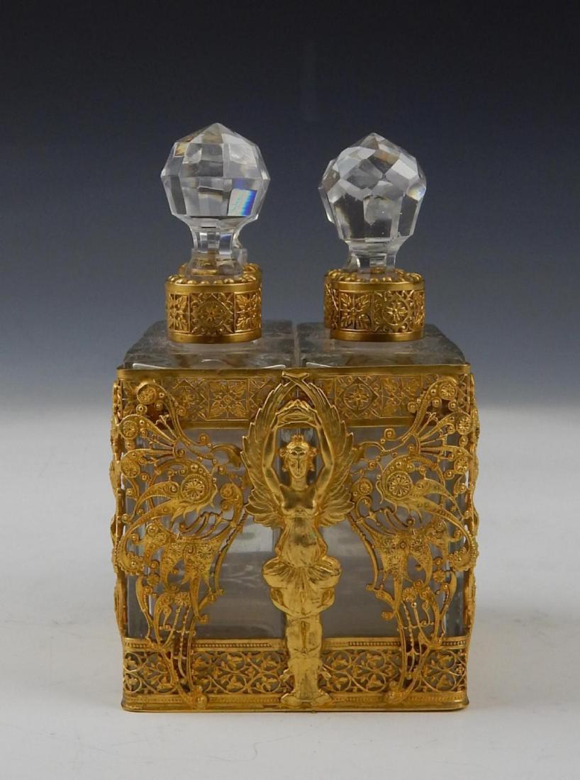 UNSIGNED BACCARAT CRYSTAL DORE MOUNTED SCENT BOTTLE: Antique unsigned Baccarat clear crystal perfume scent bottle having a four compartment design with stoppers. Mounted with gold gilt ormolu bronze depicting winged women holding a crown with intricate 