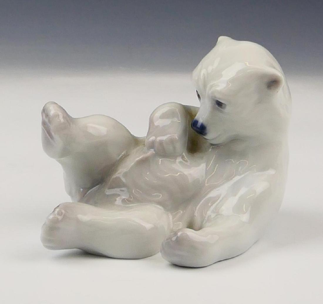 ROYAL COPENHAGEN PORCELAIN POLAR BEAR CUB 88: Royal Copenhagen Danish porcelain animal sculpture depicting a recumbent polar bear cub. Marked to bottom and numbered 88. Measures approx. 3 1/2" height x 4 1/2" length (8.9cm x 11.4cm).