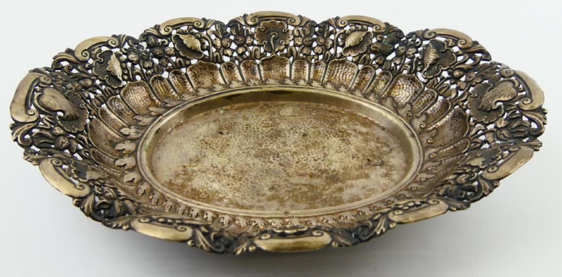 LOT OF 2 INDONESIAN SILVER FOOTED BOWL & PLATTER: A lot of two Indonesia silver items to include a footed round platter having a repousse design depicting lotus blossoms with scrolled vines. Lot is also to include a footed oval bowl with pierced lotu