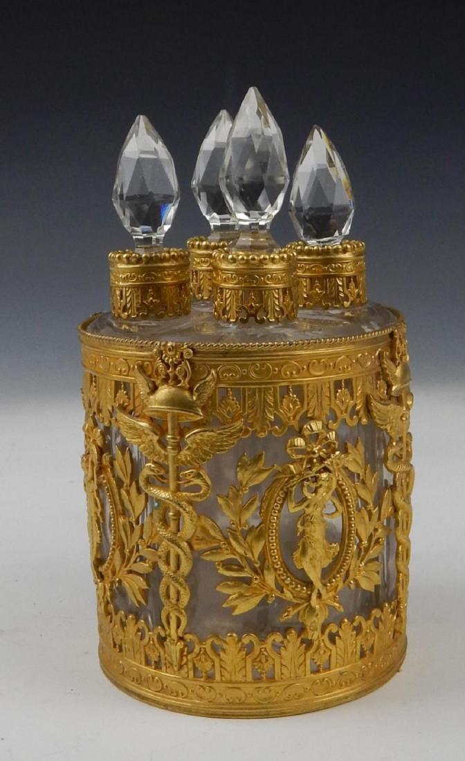 UNSIGNED BACCARAT CRYSTAL DORE VANITY SCENT BOTTLE: Unsigned Baccarat French clear crystal perfume scent bottle having a four compartment with stoppers design. Mounted with gold gilt ormolu bronze depicting women holding flowers and caduceus staff of H