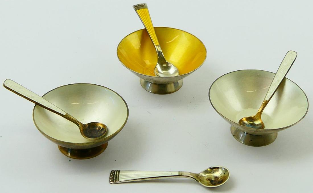 3 DANISH STERLING SILVER ENAMELED SALT CELLARS: A lot of 3 Danish sterling silver guilloche enameled salt cellars with 4 spoons. Pieces by ELA, VB and TJ. Cellars measure approx. 7/8" height x 2 1/8" diameter (2.2cm x 5.4cm). Total weight approx. 8