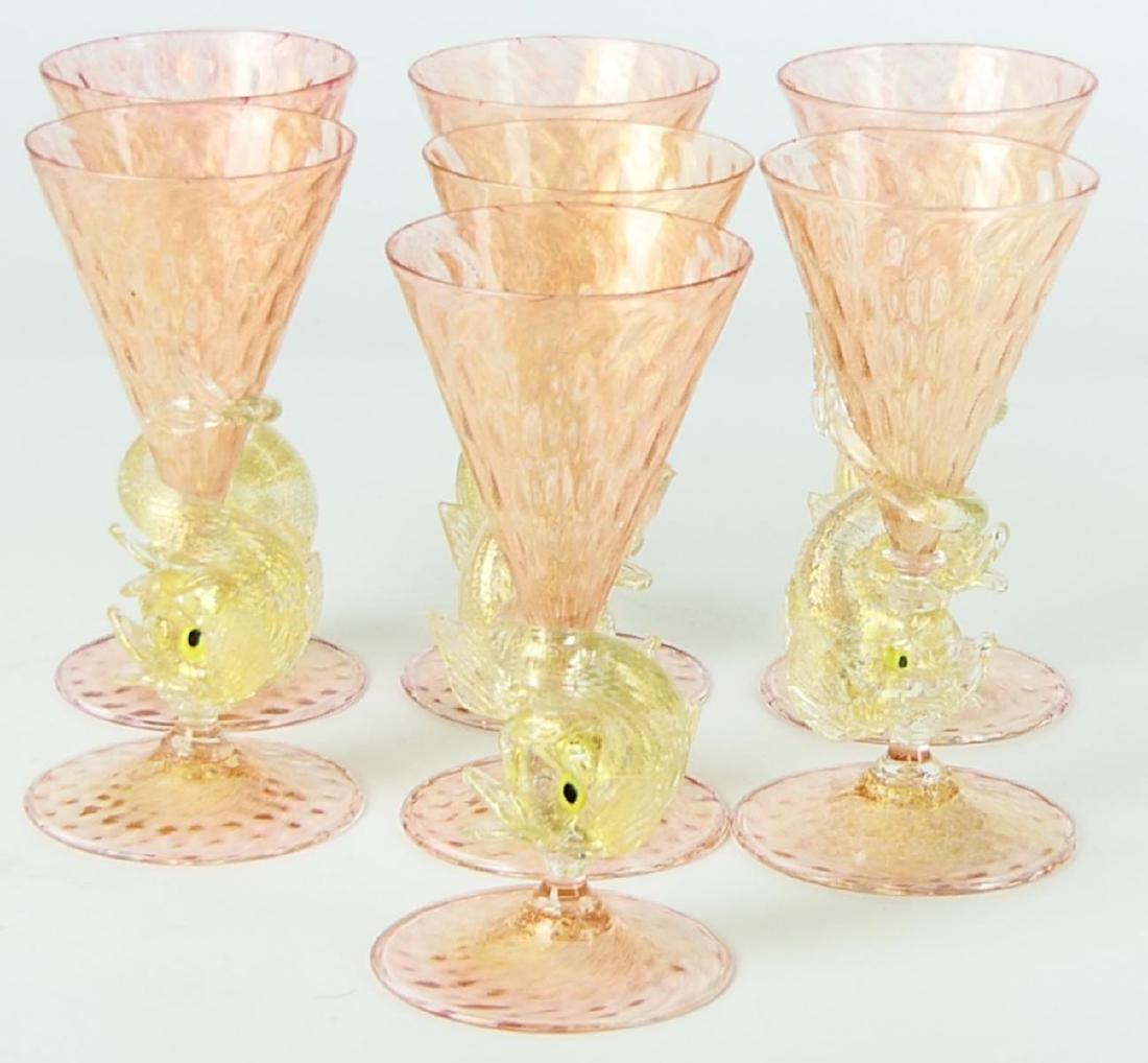 7 SALVIATI VENETIAN FIGURAL DOLPHIN WINE GLASSES: Set of 7 Salviati Venetian hand blown art glass stemmed wine glasses crafted of crandberry glass bowl and foot with clear figural dolphin stem. Gold flecking seen throughout cranberry and clear glass.