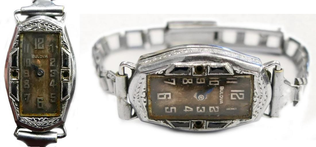 BULOVA 14K WG ART DECO WOMEN'S 15J WRISTWATCH: A vintage women's estate Art Deco wristwatch by Bulova having a 14k white gold case. Arabic numerals to dial with cobalt blue metallic hour hand (minute hand appears to be missing). Case set with genu