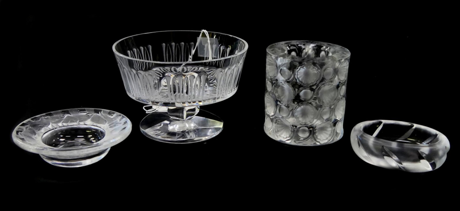 LOT OF 4 LALIQUE FRENCH CRYSTAL TABLEWARE ITEMS: A lot of 4 Lalique clear and frosted French crystal tableware items to include an "Isabelle" open candy dish, "Tokyo" cigarette holder / votive vase, an "Irene" ashtray and a "Yseult" salt dip. Larges