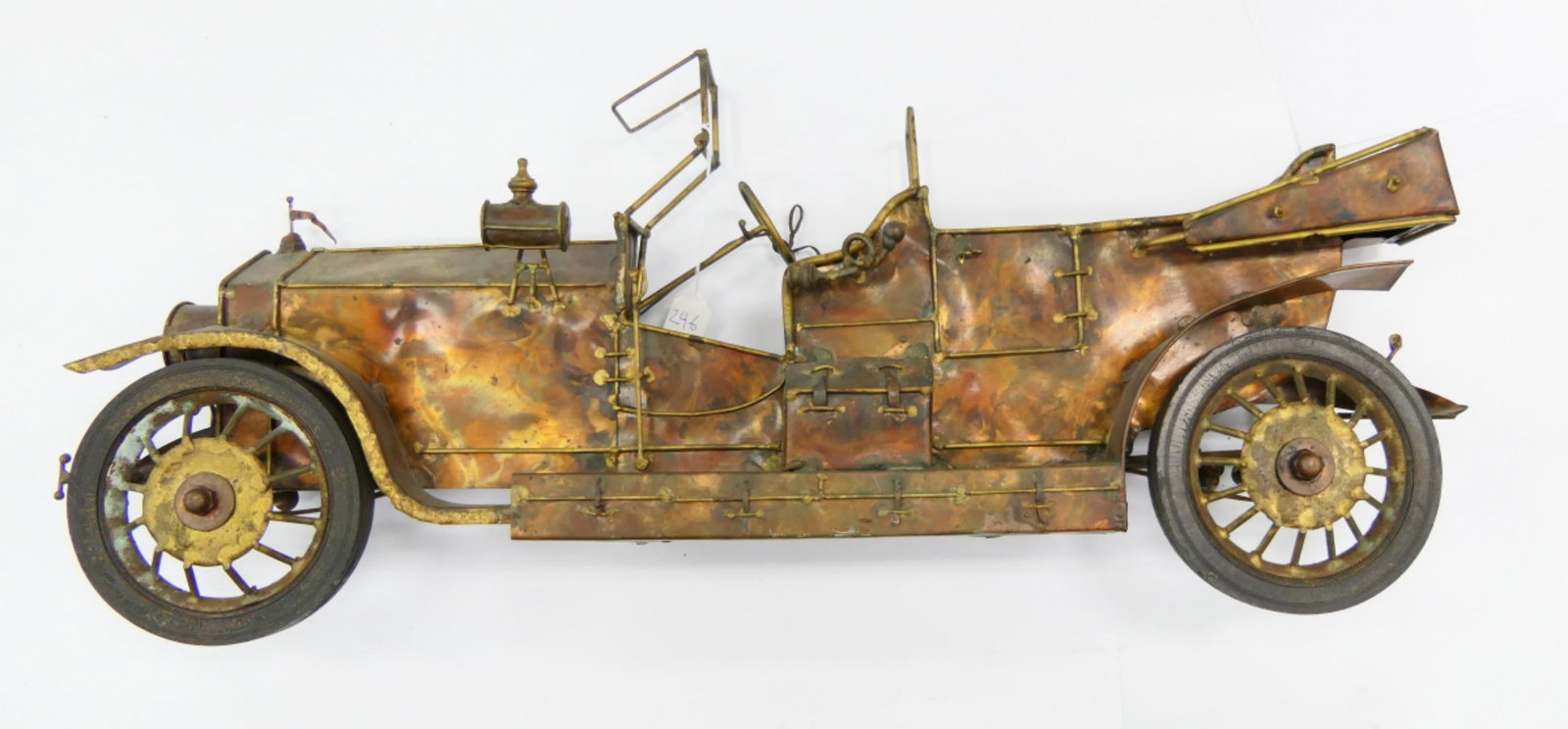 HAND CRAFTED METAL FIGURAL CAR WALL SCULPTURE: A hand crafted metal wall art sculpture depicting an antique car. Measures approx. 15" height x 33 1/2" width (38.1cm x 85cm).