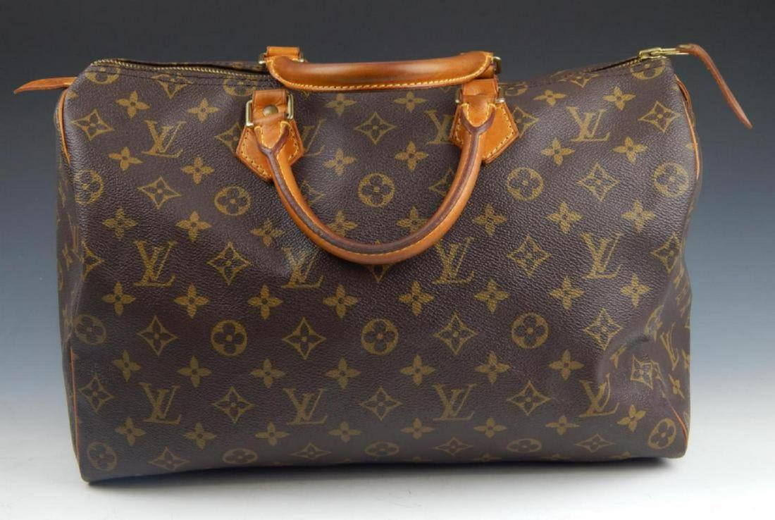 LOUIS VUITTON BROWN CANVAS MONOGRAM HANDBAG PURSE: Louis Vuitton designer handbag Speedy purse having a classic brown leather Monogram canvas design. Includes lock and two keys. Interior with brown fabric and one hanging flap pocket. Measures approx. 