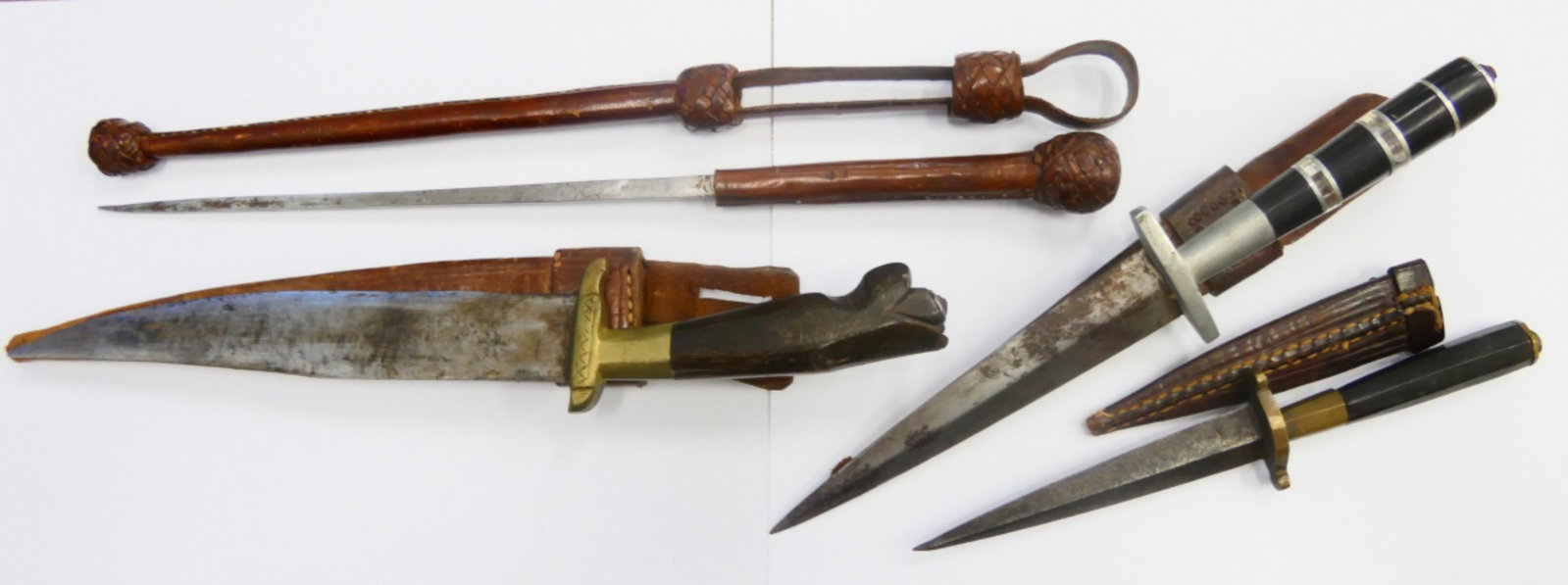 LOT OF 4 VINTAGE DAGGERS WITH LEATHER SHEATHES: A lot of 4 vintage dagger knives with leather sheates. One with black and clear bakelite blade, 2 with wooden handles and a square blade knife. Longest measures approx. 13 3/4" long (34.9cm) overall i