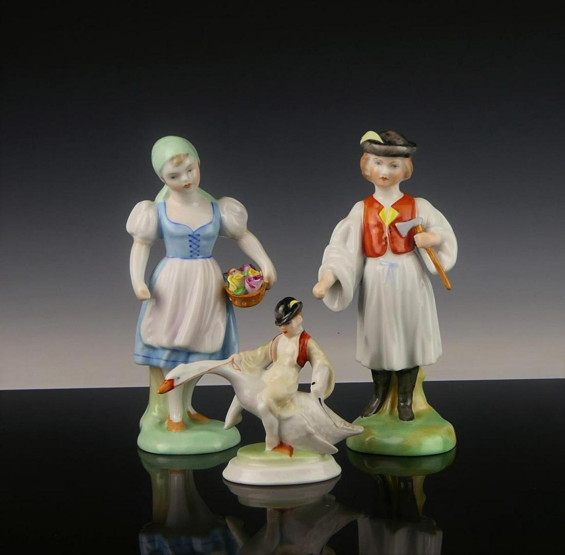 LOT OF 3 HEREND HUNGARIAN PORCLEAIN FIGURES: A lot of 3 Herend Hungarian hand painted porcelain figures to include a boy on goose, boy with hatchet and a girl with flower basket. Each with blue hallmark to bottoms. Tallest piece approx. 6" heigh