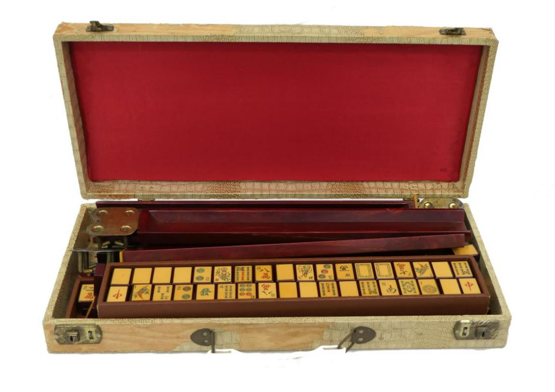 VINTAGE BAKELITE MAHJONG SET WITH BOX: Vintage Bakelite Mahjong set having faux ivory & deep cherry red amber two tone tiles with etched polychrome designs. All 152 tiles present. Includes 5 deep cherry amber rails. No chips. Case having c