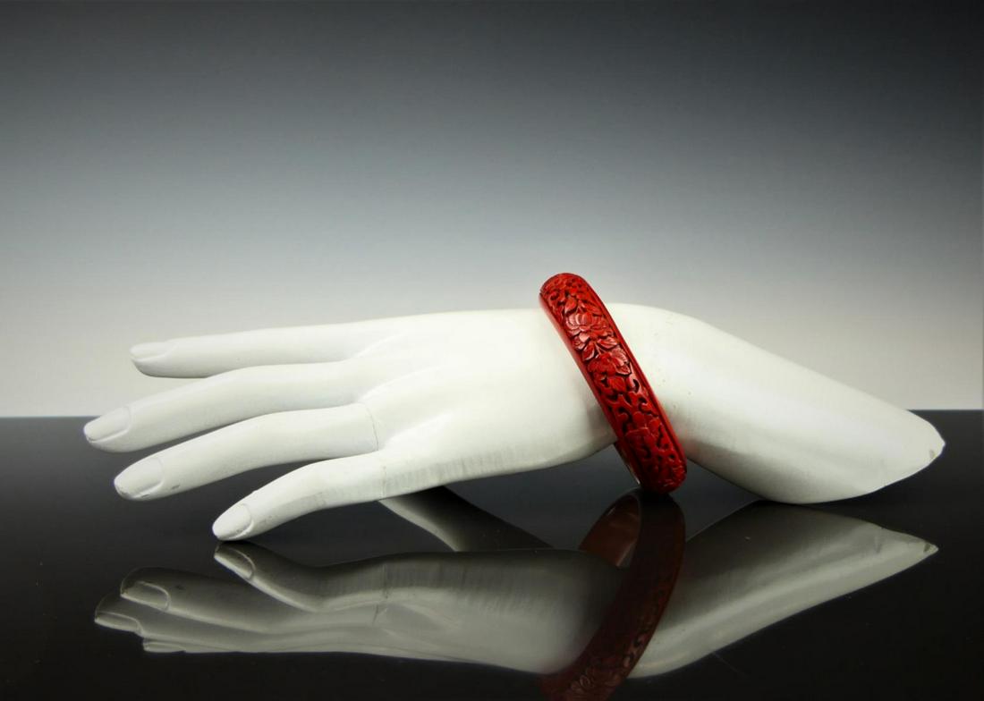 CHINESE CARVED CINNABAR BANGLE: 3" In diameter from a Palm Beach estate. Third party shipping required .