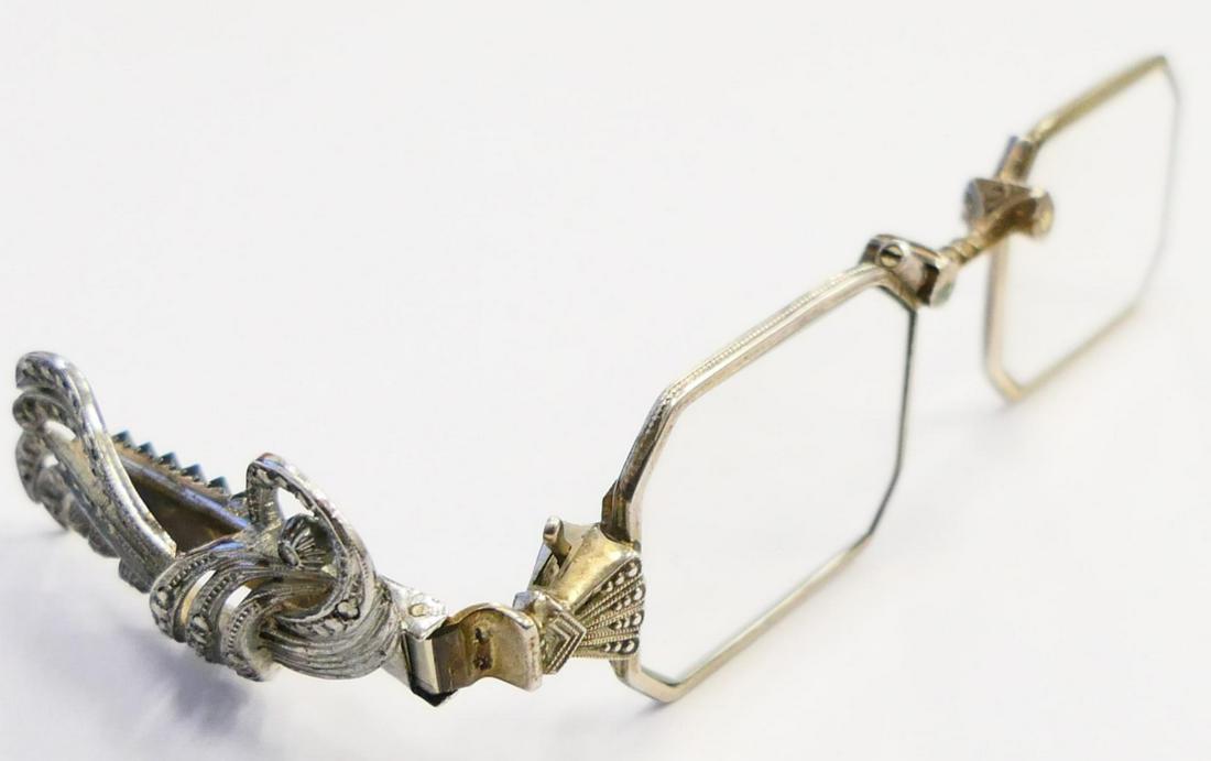PAIR ANTIQUE WG PLATE FOLDING READING GLASSES: A pair of antique mechanical folding reading glasses having a white gold plated finish. Completed with folding marcasite jeweled handle. Hinges and mechanics appear nice and firm. Measures approx. 4 3