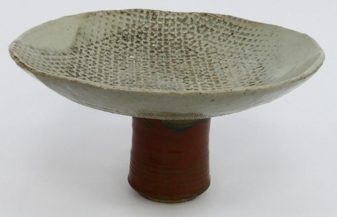 LARGE POTTERY PEDESTAL PLATE SIGNED ILLEGIBLY: We cannot read the signature so we are including close up views for you. This pottery dish measures 9 1/2" tall, and 13" wide. The base is in a red earth tone color glaze. Third party shipping require
