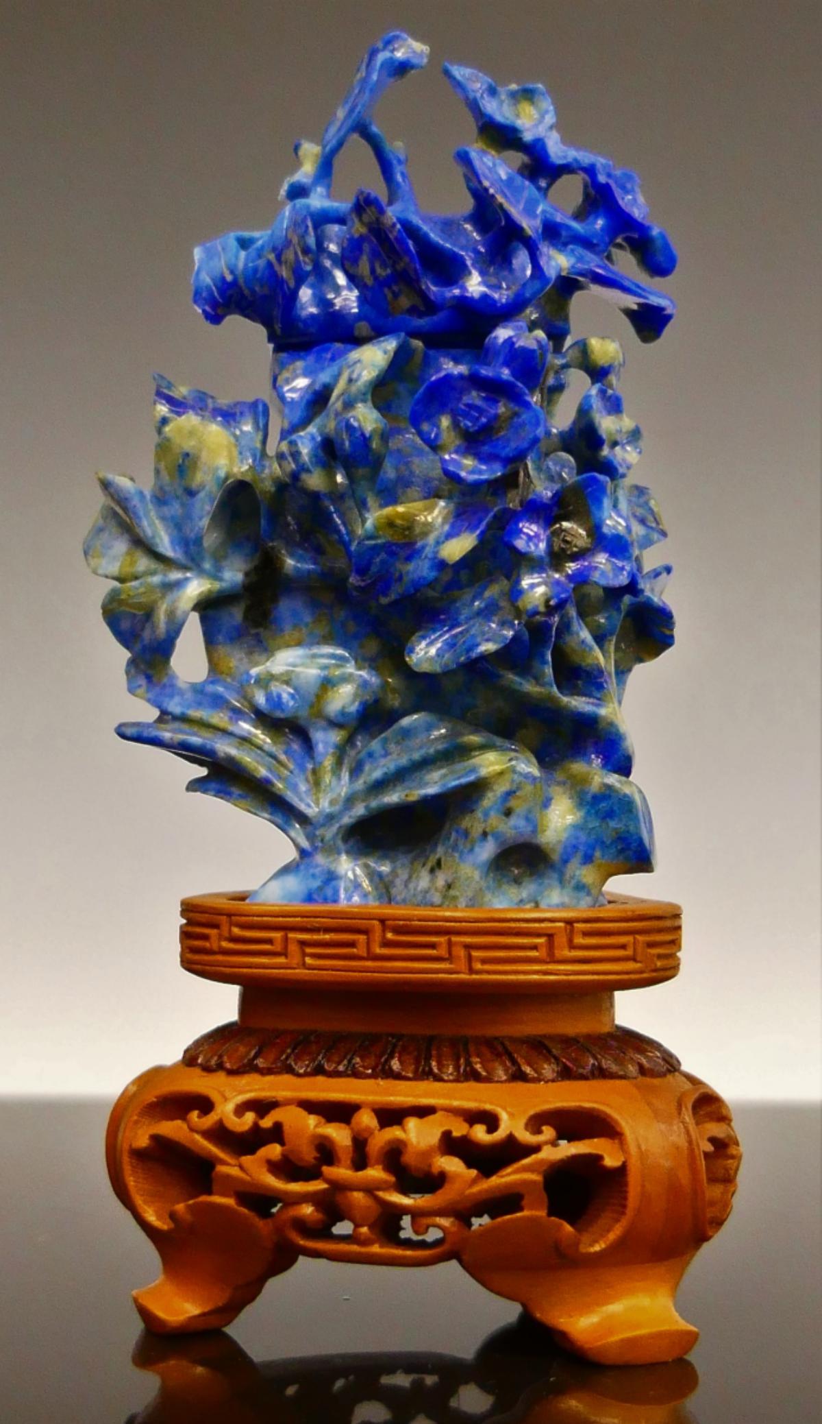 CHINESE CARVED SODALITE COVERED CABINET VASE: Intricately carved Chinese sodalite stone covered cabinet urn vase having reticulated raised floral blooms on branches with leaves design. Includes fitted wooden base. Measures approx. 5 1/4" height (