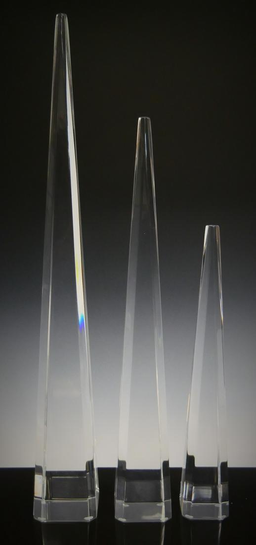 3 CLEAR LUCITE GRADUATING OBELISK SCULPTURES: A set of three clear lucite graduating obelisk phallic sculptures. Tallest measures approx. 19 1/2" height (49.5cm).