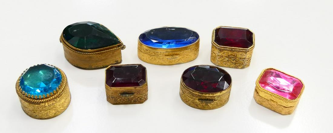 LOT OF (7) FIORENZA ITALIAN FANCY PILL BOXES: Each measures between 1"-2" . Scrolled brass boxes with lovely colored glass tops. All in excellent condition. Third party shipping required