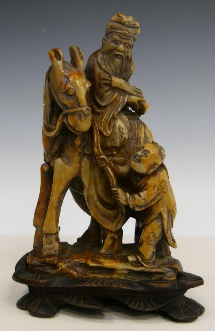 FINE CHINESE YELLOW & RED SOAPSTONE WISEMAN GROUP: A finely carved Chinese yellow and red soapstone group depicting a wiseman on horseback with attendant. Includes fitted wooden base. Measures approx. 5" height (12.7cm) overall including base.
