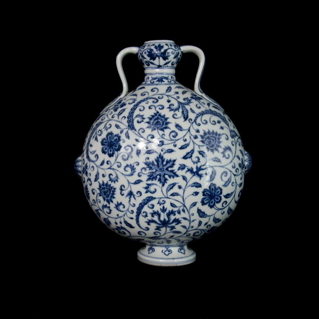 CHINESE BLUE & WHITE PORCEALIN MOON FLASK VASE: Chinese blue and white porcelain vase of moon flask form depicting floral blooms amongst scrolled vines. Measures approx. 11 1/8" height (28.3cm).