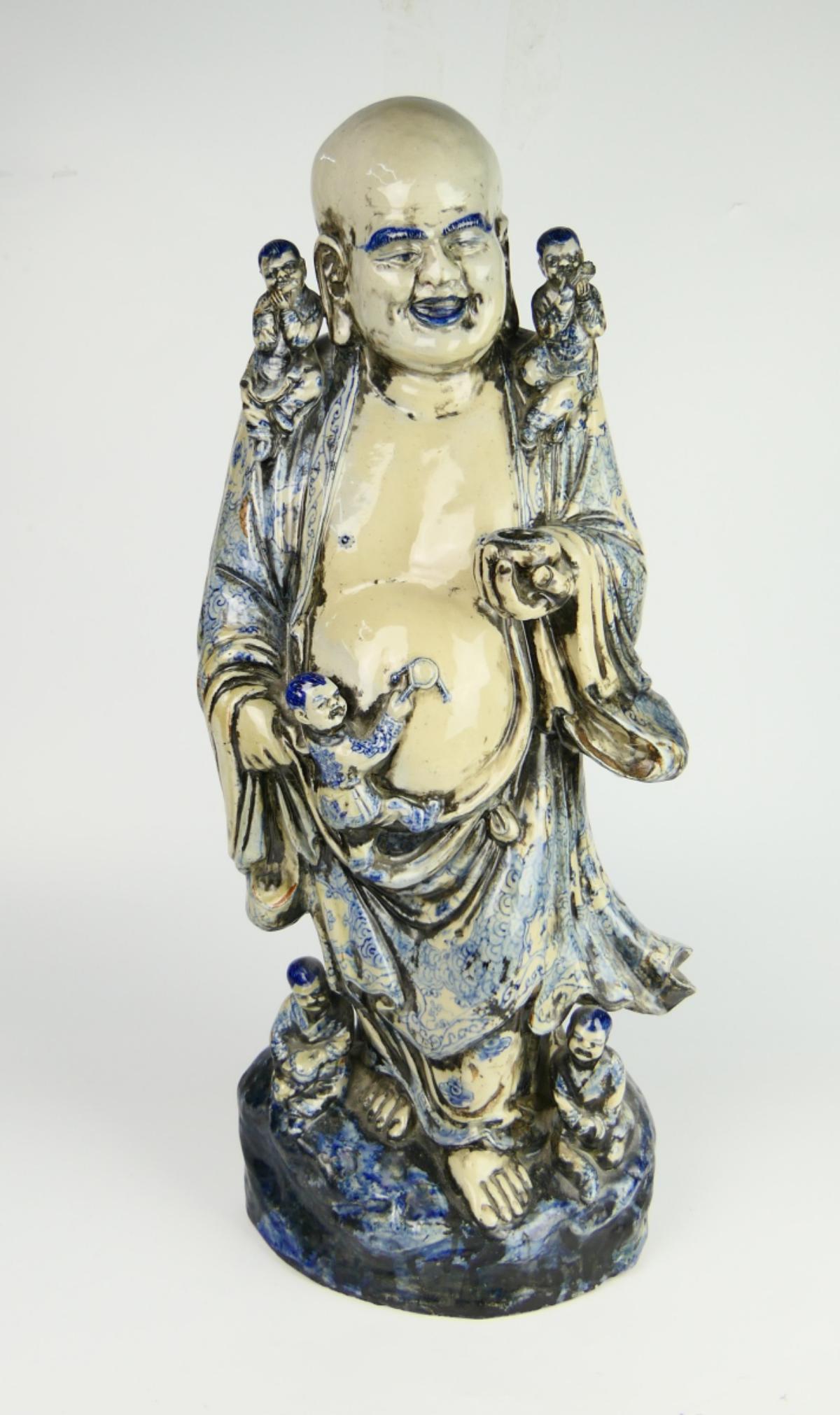 LARGE & HEAVY CHINESE BLUE & WHITE HOTEI BUDDHA: A large and heavy Chinese blue and white glazed pottery sculpture depicting a standing Hotei Buddha with attendants. Measures approx. 27 1/4" height (69.2cm).