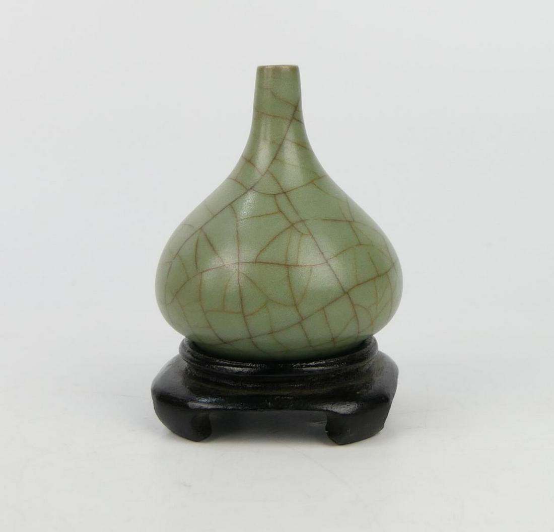 CHINESE SONG KUAN YAO WATER DROPPER PROF WU: Chinese Song dynasty Kuan Yao water dropper coup with small mouth and low bulbous body on footed base. Light gray glaze with wide darker crackles throughout. Includes hardwood display stand. Measures 