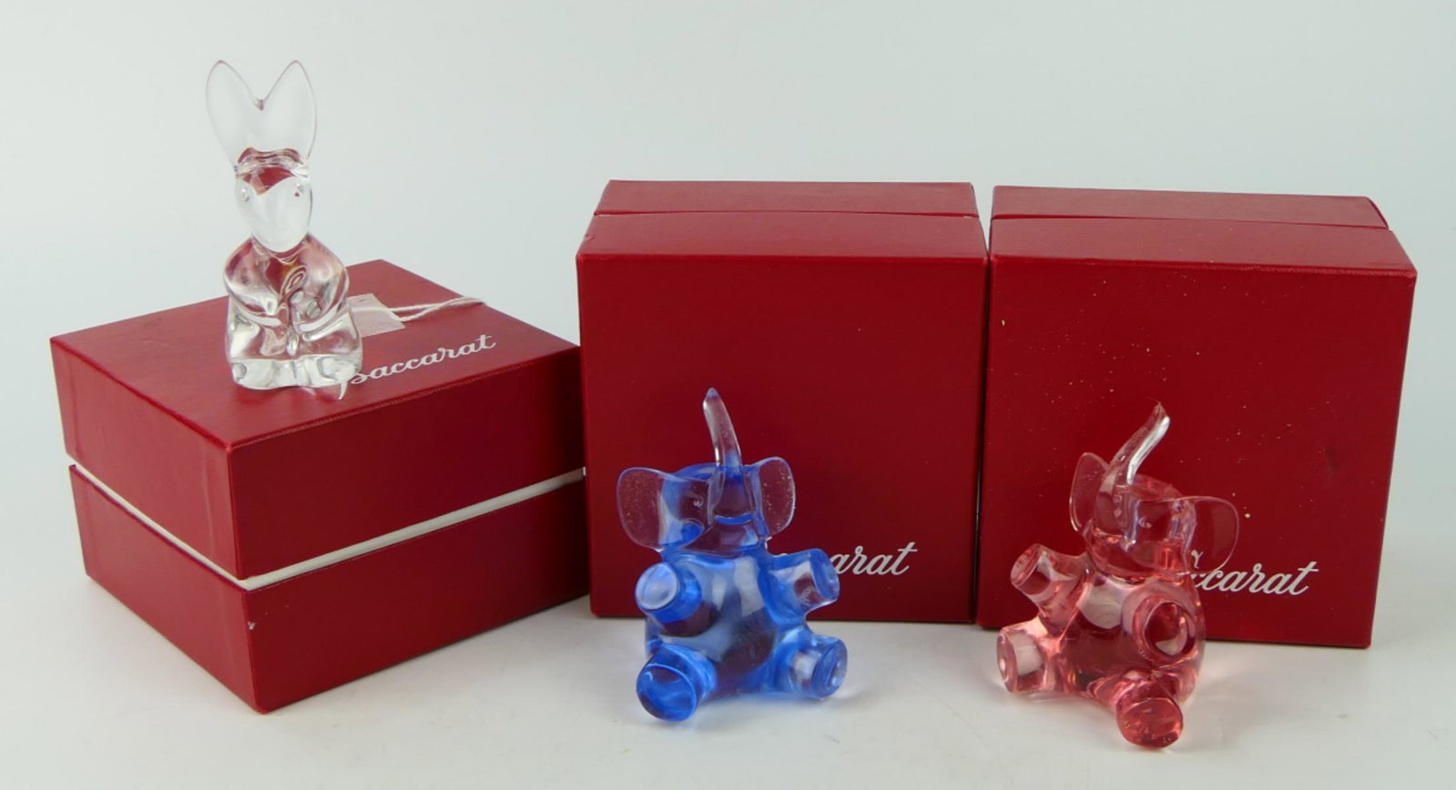 BACCARAT (3) PIECES ELEPHANT & RABBIT CRYSTAL BOX: We offer for auction, a pink and a blue baby elephant, trunks up each 3" tall with original boxes and a Baccarat 3" crystal bunny also in original box