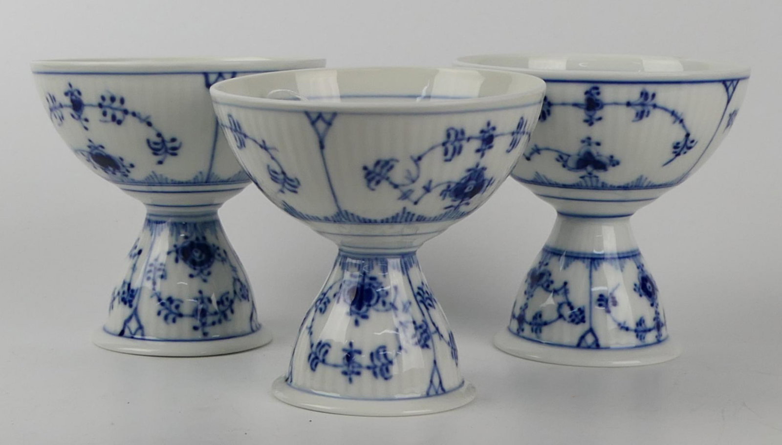 3 ROYAL COPENHAGEN BLUE FLUTED DOUBLE EGG CUPS: Royal Copenhagen, Blue Fluted double Egg Cups number 301. Measures approx 3 1/2" .