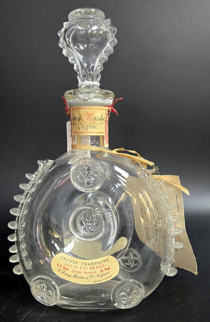 BACCARAT REMY MARTIN COGNAC BOTTLE DECANTER: A French glass Baccarat for Remy Martin glass Cognac bottle decanter with stopper. Fully hallmarked to bottom and has label. Measures approx. 11 1/4" height x 7" width.