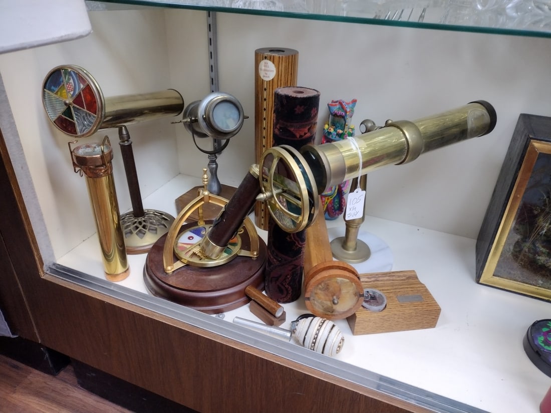 COLLECTION OF 14 VARIOUS KALEIDOSCOPES: A collection of 14 various material Kaleidoscopes crafted of metal, glass, wood and more. Also includes a set of screens with stand. Longest dimension approx. 14" length.