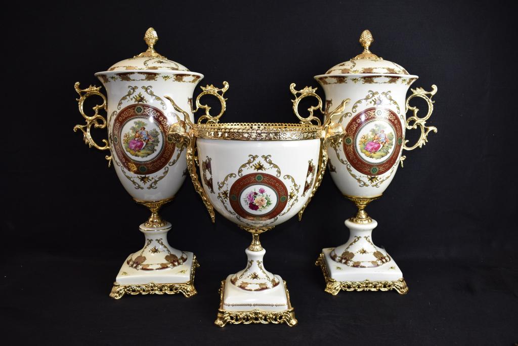 3 PC. FRENCH STYLE PORCELAIN & METAL GARNITURE SET: 25" TALL ON PAIR OF LIDDED URNS--18 1/4" TALL ON CENTER PIECE--HAS LADY HEADS ON THE GILT METAL HANDLES