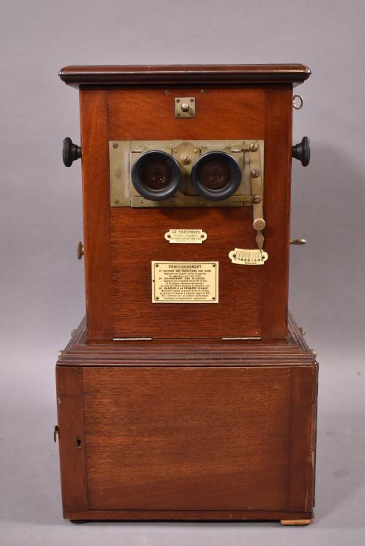 ANTIQUE LE TAXIPHOTE TABLE TOP STEREO VIEWER: DEVELOPED BY JULES RICHARD -- WITH SLIDES -- MAHOGANY CASE WITH HINGED AND LOCKED DOOR OPENING FOR GLASS SLIDES STORAGE -- BRASS HANDLES FOR CARRYING -- SMALL REPAIR TO FRONT LOWER DOOR -- SMALL SECTI