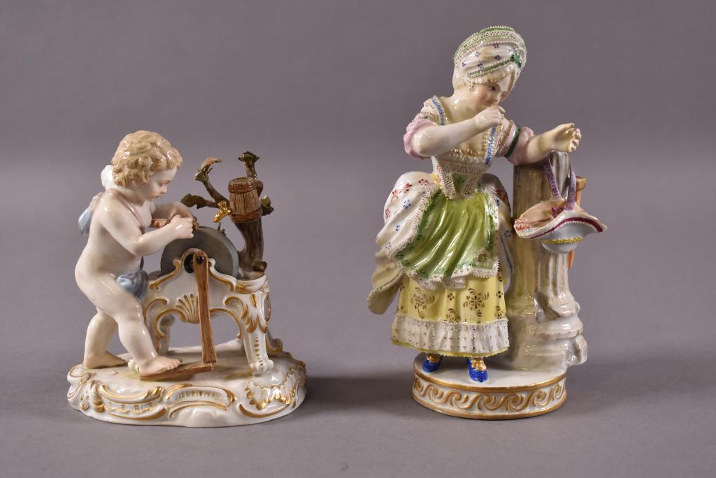 2 MEISSEN FIGURES "CUPID SHARPENING ARROWS": BLUE CROSSED SWORDS MARK ON BOTTOM. LADY COLLECTING ARROWS IN HER BONNET. & LATE 18TH C. "CUPID SHARPENING ARROWS". IMPRESSED C62. BROKEN FLOWERS AND MISSING WING. LADY COLLECTING ARROWS LEFT ARM HAS 