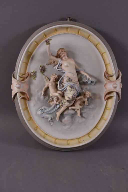 KPM STYLE PORCELAIN WALL PLAQUE: OVAL WALL PLAQUE WITH MOTHER AND 2 CHERUBS. MARKED ON BASE WITH BLUE STAMP AND NUMBERED 53. SOME DAMAGE TO FLOWERS. ALL OTHERS IN GOOD CONDITION. 13 1/2" x 11 1/4"