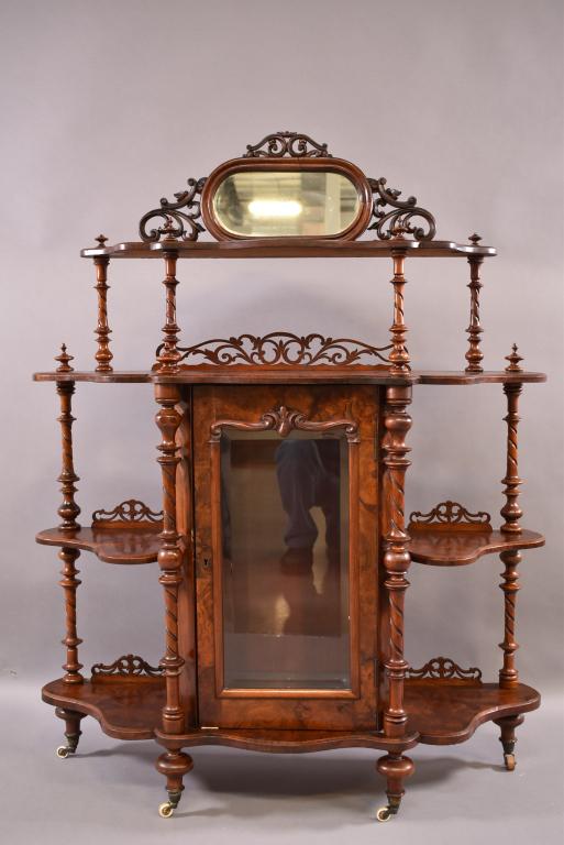 VICTORIAN ROSEWOOD ETAGERE W/ BEVELED GLASS: OVAL MIRRORED TOP & SINGLE DOOR WITH BEVELED GLASS LOWER CABINET. FINISH IS GOOD THROUGHOUT. TOP TWO REAR FINNIALS HAVE DAMAGE. NO INTERIOR LOWER SHELF. NO KEY. 43" x 13 1/2" x 53 1/2"