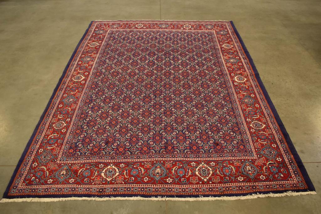 APPROX. 10'5" X 7'3" HANDMADE PERSIAN WOOL RUG: GOOD CONDITION, VERY CLEAN RUG. BLUE FIELD WITH RED BORDER. WITH ALL OVER PATTERN.