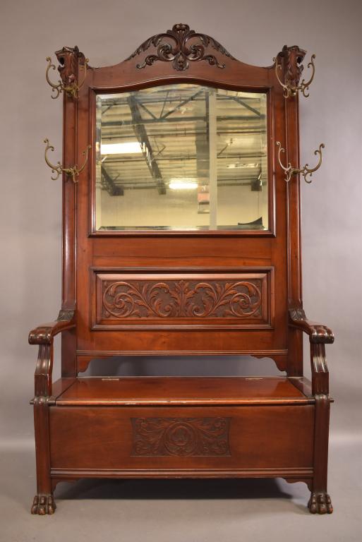 1900'S MAHOGANY HALL TREE W/ SEAT: PAINE'S FURNITURE CO. CARVED LION DESIGN WITH CLAW FOOT. HINDGED SEAT AND BEVELED MIRRORED BACK 4 ORIGINAL DOUBLE BRASS HOOKS. GOOD CONDITION. 47" x 20" x 84"