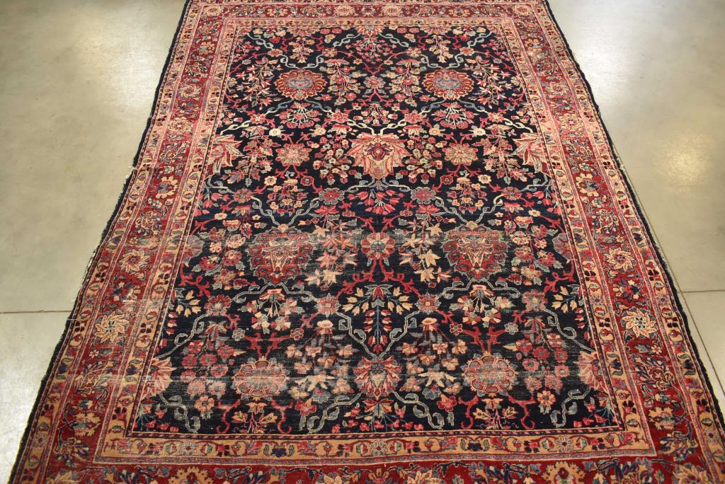 APPROX 115" x 82" HANDMADE PERSIAN WOOL RUG: HEAVILY WORN AND HAS EDGE DAMAGE.