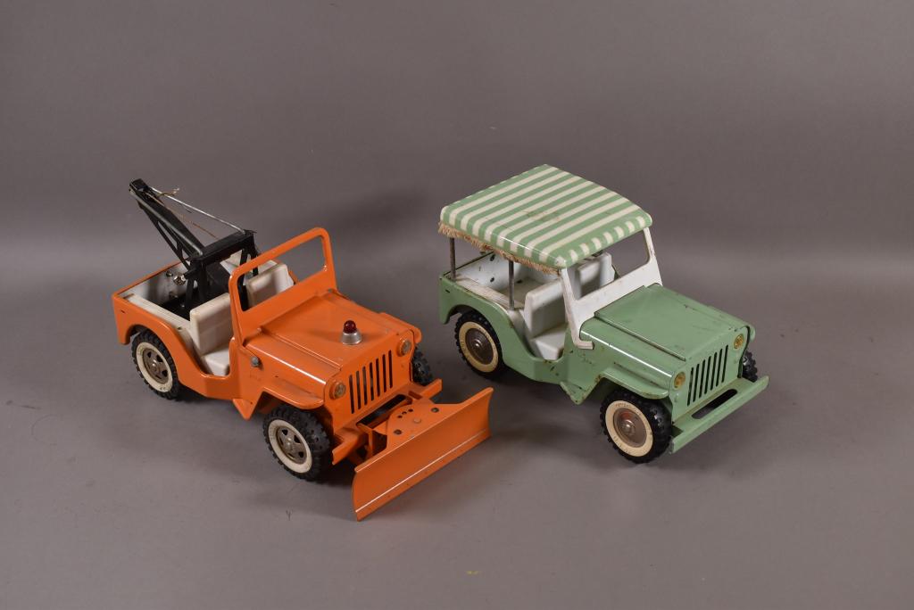 2 1950'S -60'S TONKA JEEPS: SAFARI JEEP WITH CANOPY. (9 1/2" L). TOW TRUCK WITH PLOW (11" L). SURFACE SCRATCHES AND RUST TO GREEN JEEP.