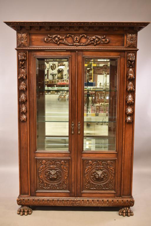 1900'S HEAVILY CARVED FIGURAL CHINA CABINET: FIGURAL CARVED UPPER AND LOWER. CLAW FOOT. MIRRORED BACK. BEVELED GLASS DOORS AND SIDES. 2 INTERIOR GLASS SHELVES. FINISH IN GOOD OVERALL CONDITION. 56" x 21" x 78" THIS ITEM EXCEEDS SIZE LIMITATIONS 