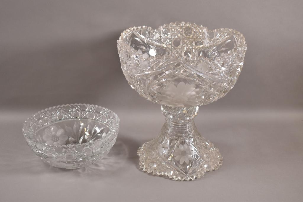 CUT GLASS PUNCH BOWL & CENTER BOWL: AMERICAN BRILLIANT DAISY PATTERN. CENTER BOWL IS 8 1/4" DIAM. HAS CHIPS ALONG EDGE. PUNCH BOWL IS 11" H x 10" DIAM. HAS CHIPS ALONG LOWER AND UPPER EDGE.