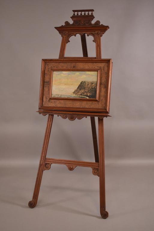 VICTORIAN WALNUT PAINTER'S EASLE: OIL ON BOARD PAINTED FRONT. DROP FRONT PAINTER'S EASLE. MINOR FINISH WEAR. LOCK DOES NOT WORK. GOOD OVERALL CODITION. 28" W x 70" H. THIS ITEM EXCEEDS SIZE LIMITATIONS FOR IN HOUSE SHIPPING.
