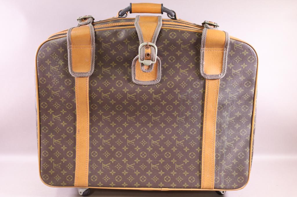 VINTAGE ROLLING SUITCASE: LOUIS VUITTON STYLE. NOT AUTHENTICATED . TEAR BY CENTER BUCKLE