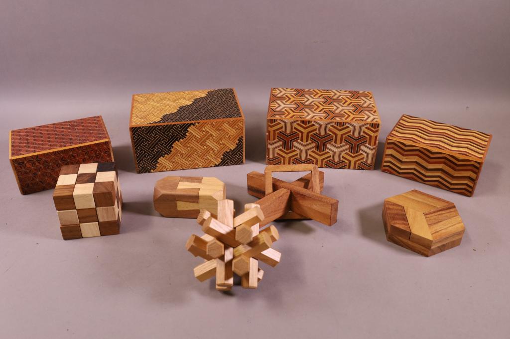 9 WOODEN PUZZLES: GROUPING OF 9 WOODEN PUZZLES. VARIOUS DESIGNS AND SIZES. WITH INCLUDED PUZZLE BOOKS.