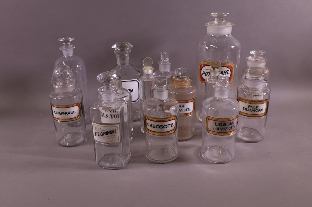COLLECTION OF APOTHECARY JARS: 14 APOTHECARY JARS, ALL WITH LIDS. SOME STOPPERS HAVE CHIPS. 7" - 12" H.