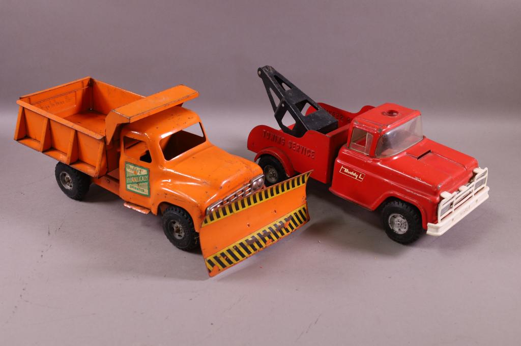 BUDDY L TOW TRUCK & DUMP TRUCK: DUMP BED WORKS. DUMP MISSING SIREN. 13" & 16" LONG. PLAYED WITH CONDITION. SCRATCHES & PAINT LOSS.