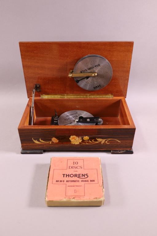 INLAID GERMAN MUSIC BOX: MARKED DEICHERT, MADE IN WEST GERMANY ON BOTTOM. INLAID CASE, SINGLE COMB. MARKED THORENS ON MECHANISM. WITH 10 DISCS. VENEER DAMAGE TO FRONT. WORKING.
