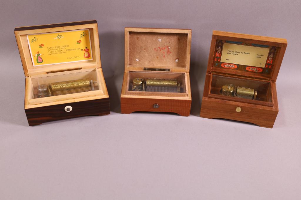 3 SMALL SWISS MUSIC BOXES: INLAID 6" W SWISS 4 SONG MUSIC BOX, MARKED LADOR, COMB IN GOOD CONDITION, WORKING. INLAID 5" W SWISS MUSIC BOX, MARKED LADOR, DATED 1945. NON WORKING. & 5 1/2" W SWISS MUSIC BOX, 2 SONG, MARKED REUGE.