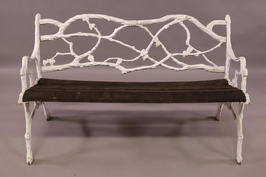 CAST IRON GARDEN BENCH: WOOD SEAT, CAST IRON BENCH. BRANCH AND LEAF FORM. MINOR RUST TO FEET. 51" W x 22" D x 30" H. THIS ITEM EXCEEDS SIZE LIMITATIONS FOR IN HOUSE SHIPPING.
