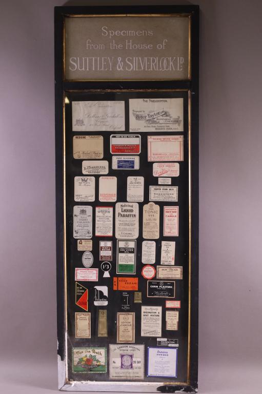 FRAMED ANTIQUE SPECIMEN LABELS: SPECIMENS FROM THE HOUSE OF SUTTLEY & SILVERLOCK. PAINT LOSS TO FRAME. 38" H x 14" W.