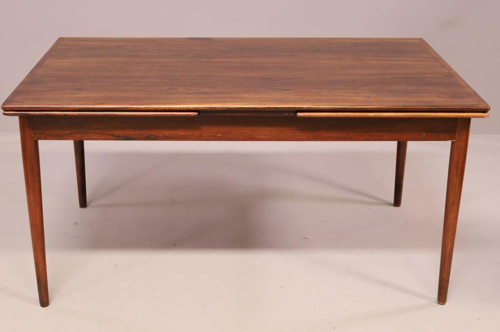 NEILS KOEFOED ROSEWOOD DINING TABLE: NEILS KOEFOD DRAWLEAF ROSEWOOD DINING TABLE. BUBBLE TO VENEER TO TOP SURFACE. 59" L x 38" W x 29" H. & LEAVES 23" W. THIS ITEM EXCEEDS SIZE LIMITATIONS FOR IN HOUSE SHIPPING.