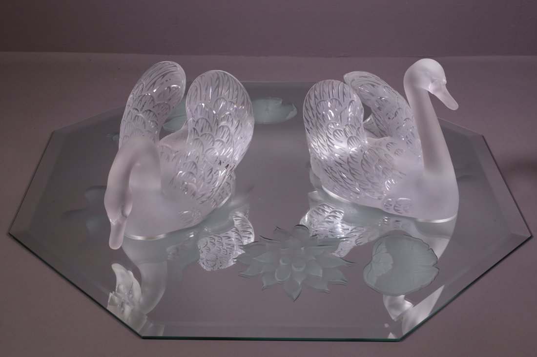 PAIR OF LALIQUE CRYSTAL SWANS WITH MIRROR: PAIR OF LARGE CRYSTAL SWANS ON BEVELED AND ETCHED MIRROR. SIGNED. CHIP TO ONE SWAN. SMALL CHIP TO MIRROR. 30 1/2" W MIRROR & 13" L x 9 1/2" H SWAN & 14" L x 7" H SWAN. THIS ITEM EXCEEDS SIZE LIMITATIO