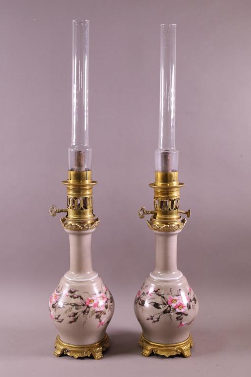 PAIR 19TH CENTURY GLASS AND BRASS OIL LAMPS: DECORATED GLASS AND BRASS OIL LAMPS, DAMAGE TO ONE. 26" H.